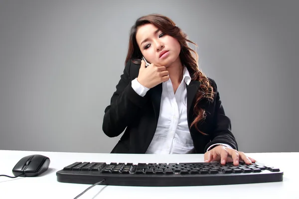 Jonge Aziatische zakenvrouw spreken op de telefoon tijdens het typen — Stockfoto