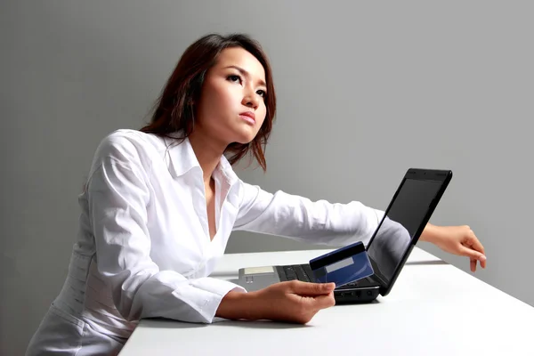 Joven mujer de negocios pensando delante de la computadora portátil —  Fotos de Stock