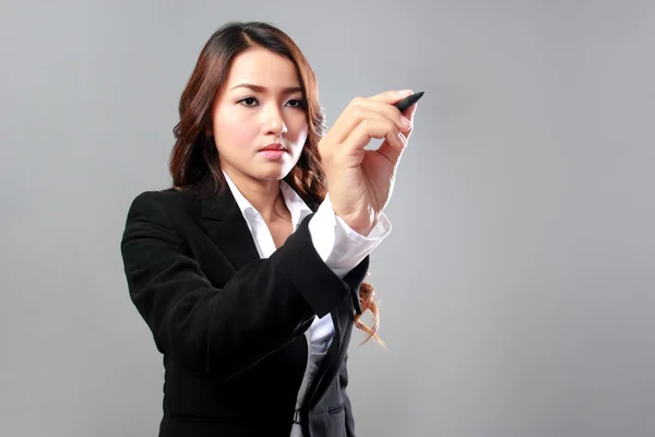 Young businesswoman writing on a virtual screen — Stock Photo, Image