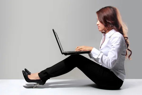 Jonge zakenvrouw werken met een laptop zittend op de f — Stockfoto