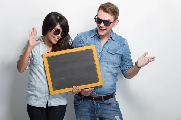 Happy Young Multiculture Couple posing with chalk board — Stock Photo, Image