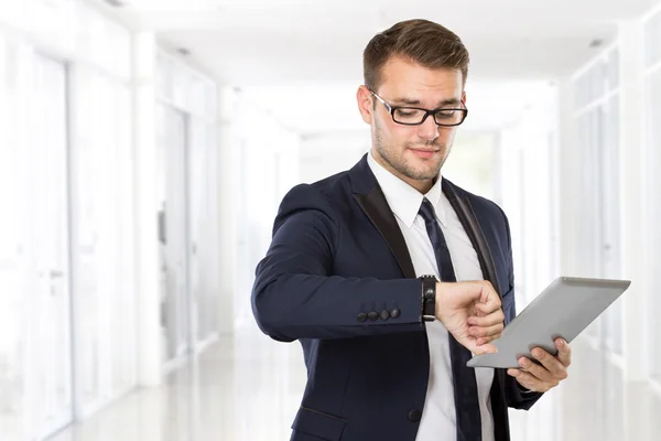 Ung affärsman med en tablett på handen — Stockfoto