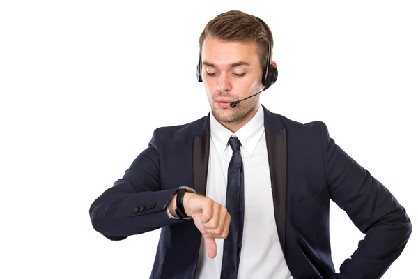 Młody biznesmen z słuchawek oglądanie jego zegarki — Zdjęcie stockowe