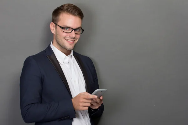 Mladý podnikatel se mobil na ruce — Stock fotografie