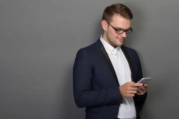 Jeune homme d'affaires avec un téléphone portable sur la main — Photo