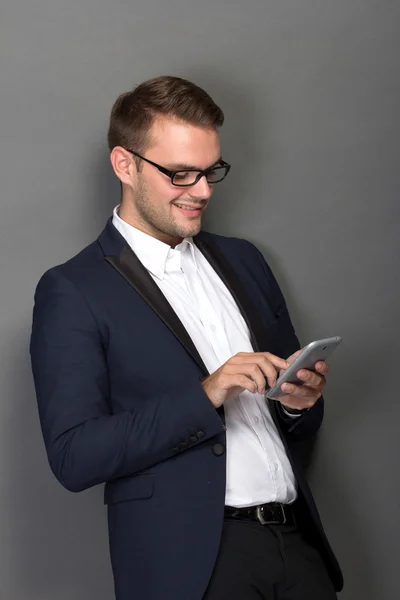 Молодой бизнесмен с мобильным телефоном на руке — стоковое фото
