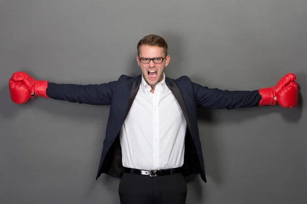 Junger Geschäftsmann mit Boxhandschuhen, schreit — Stockfoto