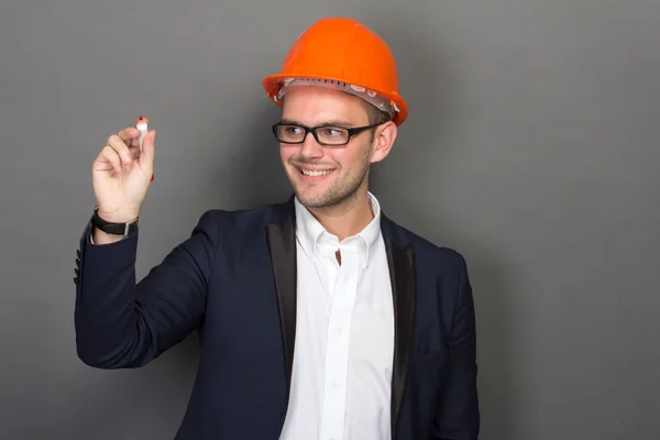 Young businessman wear a safety helmet, writing — Stock Photo, Image