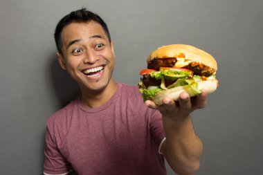 Genç adam mutlu zaman almak büyük bir burger