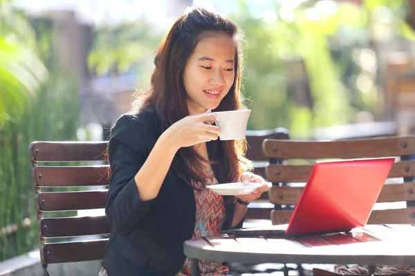 Junge Geschäftsfrau benutzt Laptop und trinkt Kaffee im Freien. — Stockfoto
