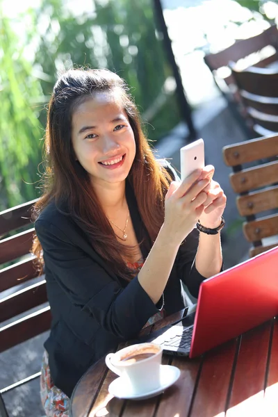 Une jeune femme d'affaires travaille à l'extérieur, dans un café — Photo