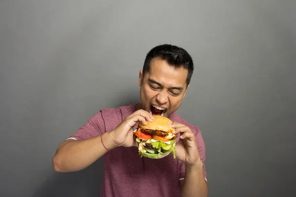 Young Man have a great desire to eat a burger — Stock Photo, Image