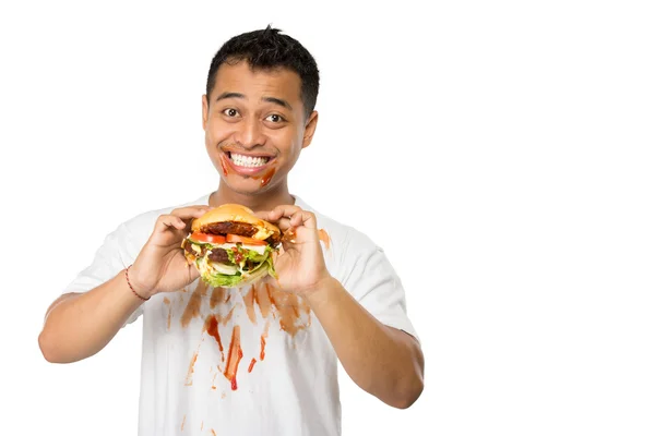 Jovem feliz comendo um hambúrguer grande — Fotografia de Stock