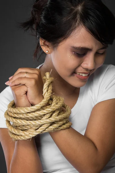 Mulher com as mãos amarradas com corda sendo abusada — Fotografia de Stock