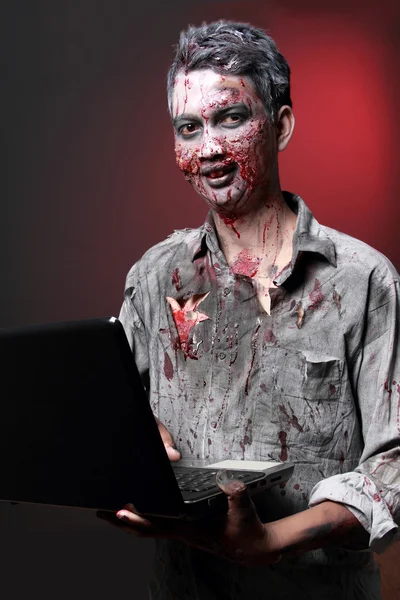 Zombie kannettavalla tietokoneella — kuvapankkivalokuva