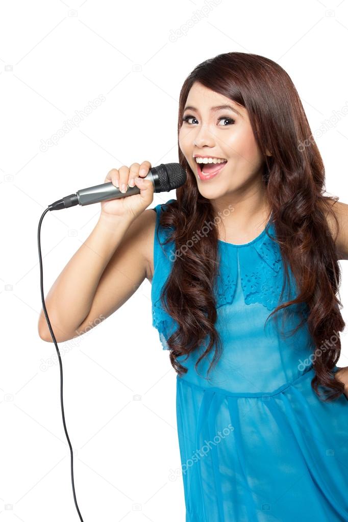 Young woman sing holding a mic, isolated