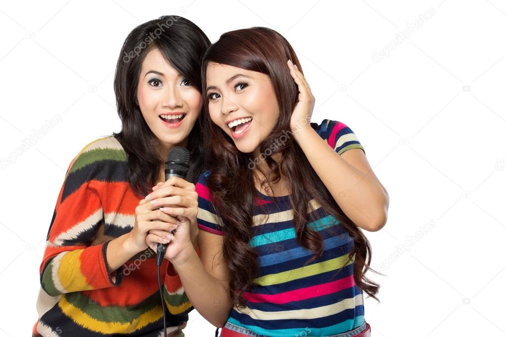 Two asian girls in striped t-shirt singing together