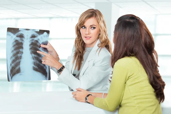 Doctora joven explicando el diagnóstico a su paciente femenino — Foto de Stock