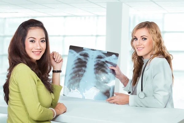 Doctora joven explicando el diagnóstico a su paciente femenino — Foto de Stock