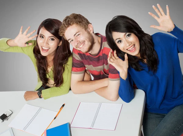 Drei lächelnde Studenten, die zusammen lernen — Stockfoto