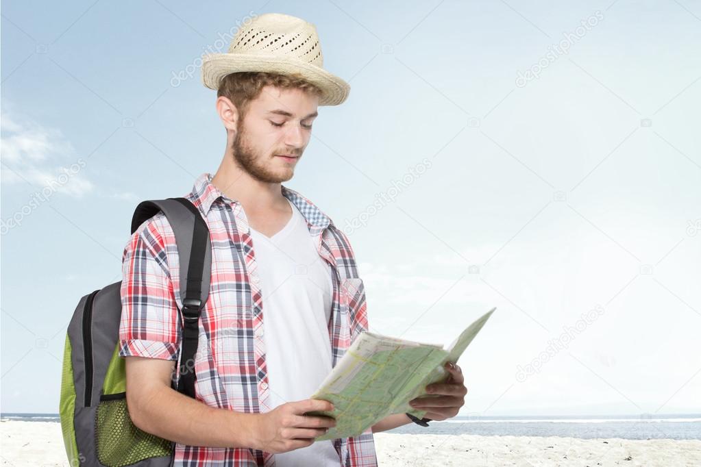 young traveling man reading map