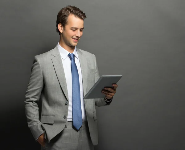 Egy tabletta és másrészt holding zsebében fiatal üzletember — Stock Fotó