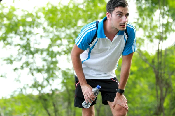 Sporty male runner taking a break after tired running — Stock Photo, Image