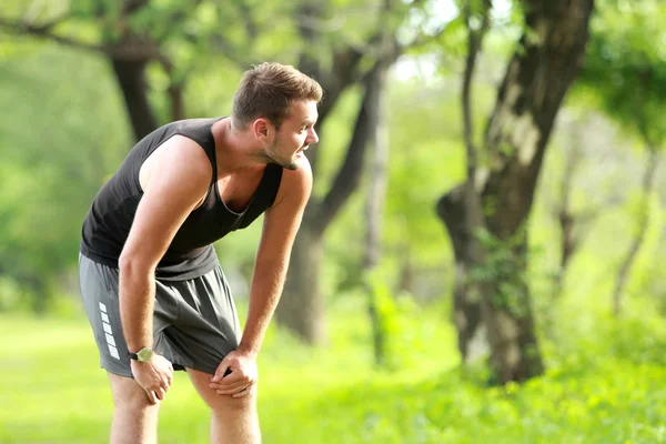 Male runner taking a break after a tired running — Stock Photo, Image