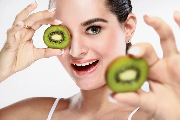 Cheerful beautiful young woman with kiwi fruit in her hands — Stock Photo, Image
