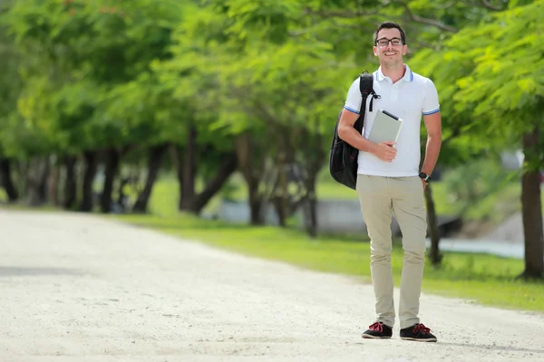 Smiling college student with backpack holding a tablet — Stock Photo, Image