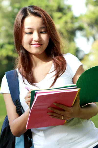 Estudante universitário gostando de estudar e escrever sobre o livro — Fotografia de Stock