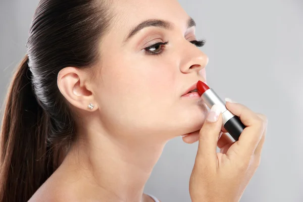 Beautiful caucasian women applying lipstick — Stock Photo, Image