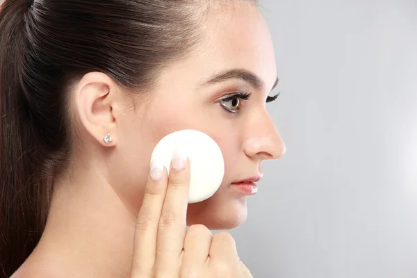 Beautiful young model holding a powder puff — Stock Photo, Image