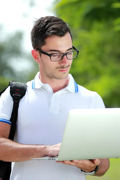 Estudiante universitario que navega por Internet usando una computadora portátil — Foto de Stock