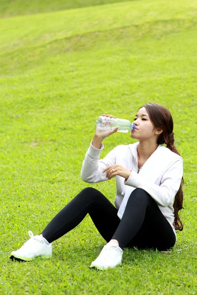 Mujer deportiva sentada y obtener refresco después del entrenamiento —  Fotos de Stock