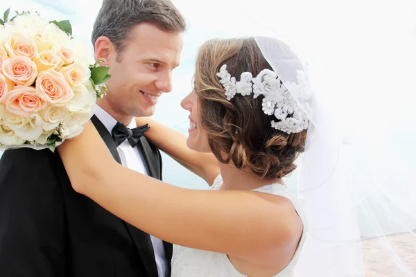 Mooie bruid glimlachend en omarmen haar bruidegom — Stockfoto