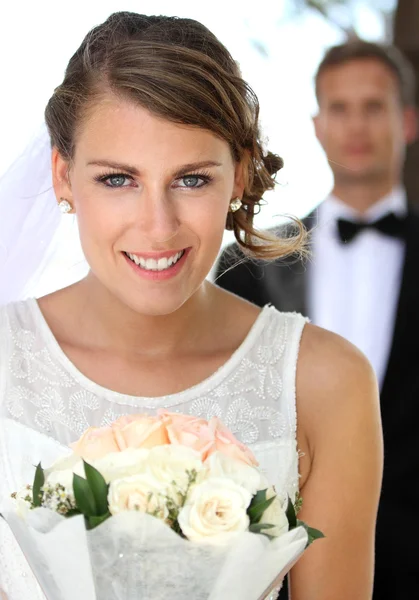 年轻美丽的新娘，微笑着，拿着一束 — 图库照片