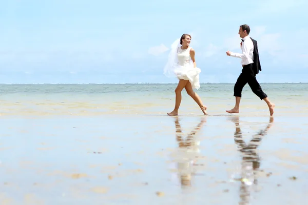 Noiva e noivo brincando na praia — Fotografia de Stock