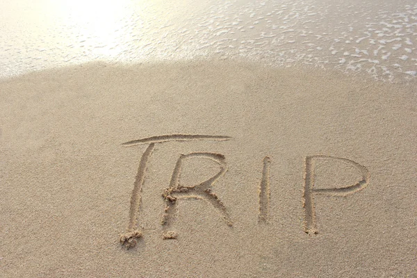 Mot "voyage" écrit sur la plage de sable — Photo