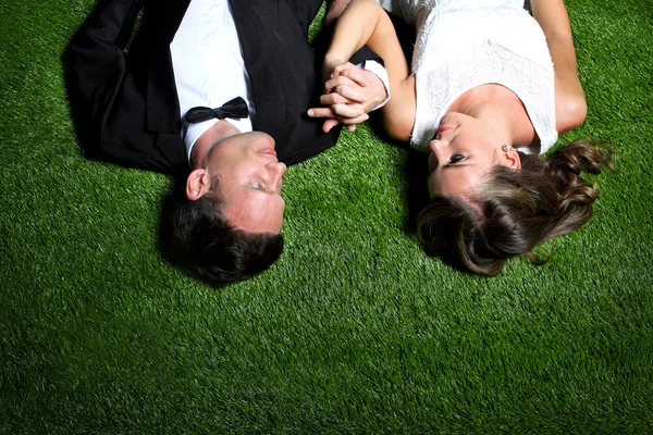 Amazing couple lying on the grass — Stock Photo, Image