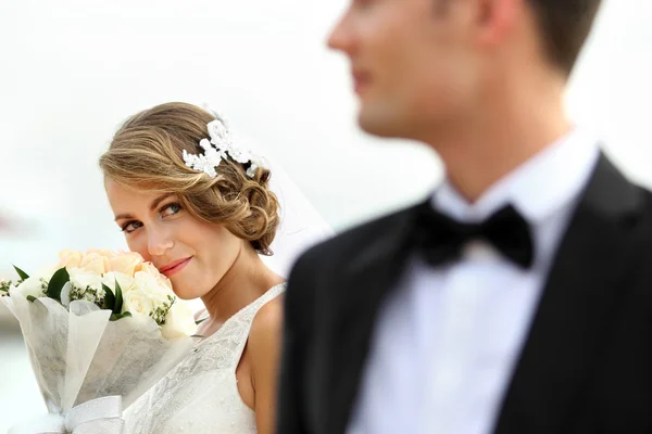 Bella sposa in possesso di un bouquet mentre guardando al suo sposo — Foto Stock