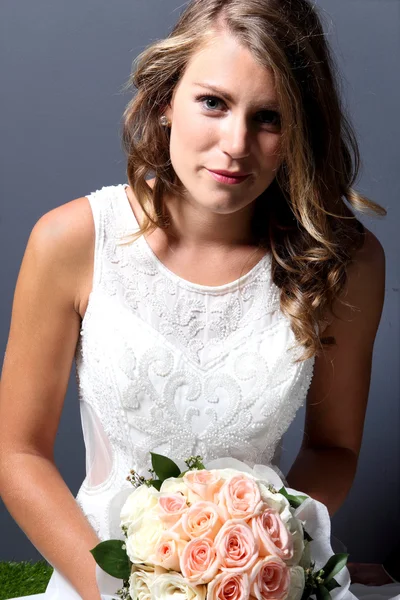 Bella sposa sorridente e con in mano un bouquet — Foto Stock