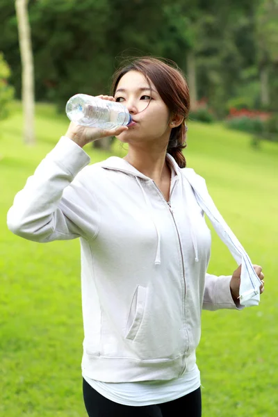 Mulher desportiva beber água mineral — Fotografia de Stock