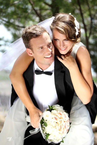 Groom pickaback his bride — Stock Photo, Image