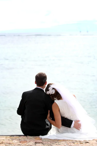 Casal recém-casado romântico sentado na praia — Fotografia de Stock