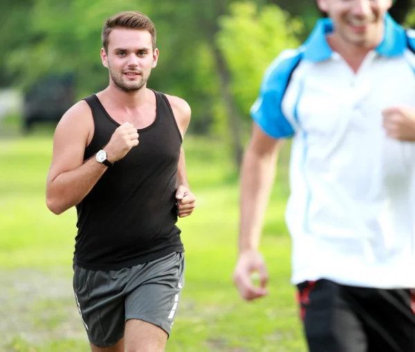 Two young sport man jogging together at roadside — Stock Photo, Image