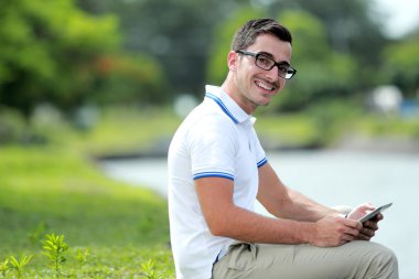 gülümseyen ve bir t tutarken kameraya bakarak üniversite öğrencileri