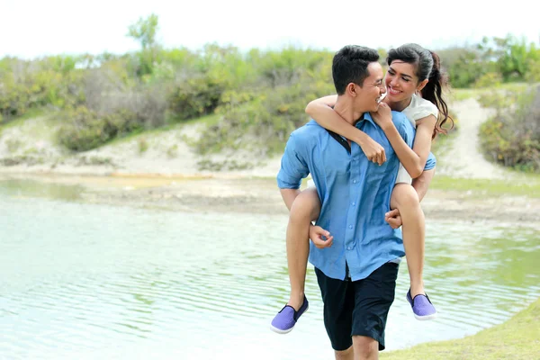 Romantico giovane uomo a cavalluccio la sua ragazza — Foto Stock