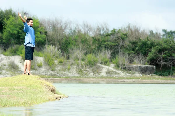 Joven se siente relajarse en la orilla del lago —  Fotos de Stock