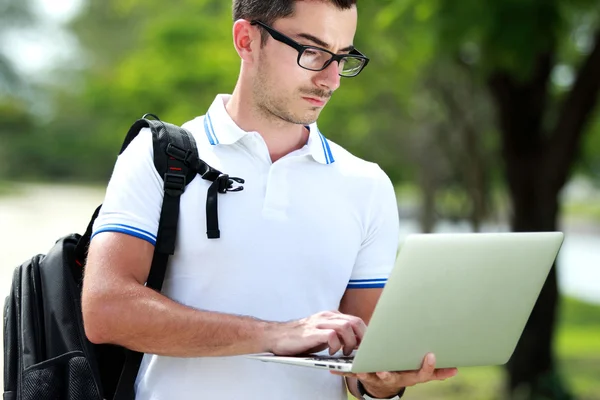 Estudante universitário navegar na internet usando um laptop — Fotografia de Stock